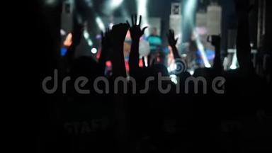 快乐观众举起双手转身摇滚乐队音乐厅剪影跳舞的人们举起双手